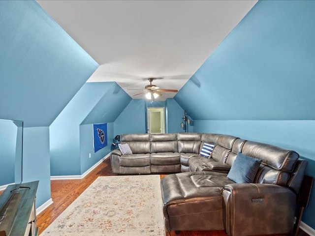 living area featuring vaulted ceiling, wood finished floors, baseboards, and ceiling fan