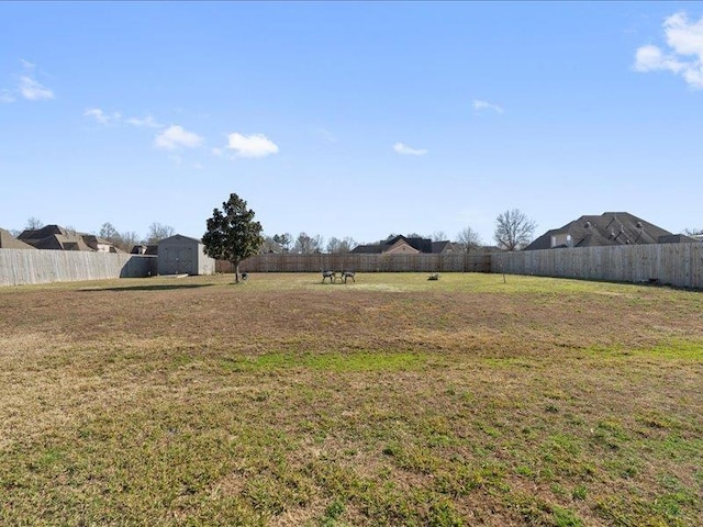 view of yard featuring a storage unit, an outbuilding, and fence