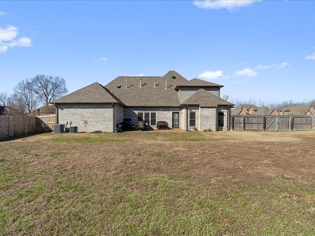 back of house with central AC, a yard, and fence