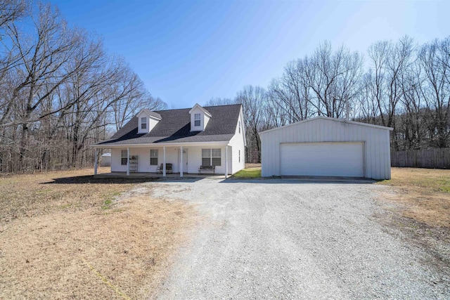 view of front facade featuring a porch, an outdoor structure, a garage, and fence