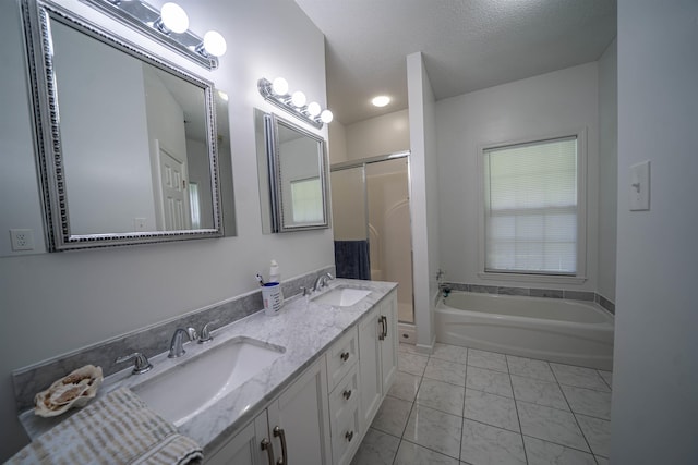 bathroom with a sink, a bathing tub, a textured ceiling, and a shower with door