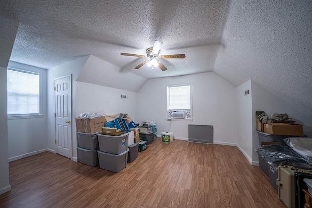 bonus room with cooling unit, baseboards, lofted ceiling, and wood finished floors