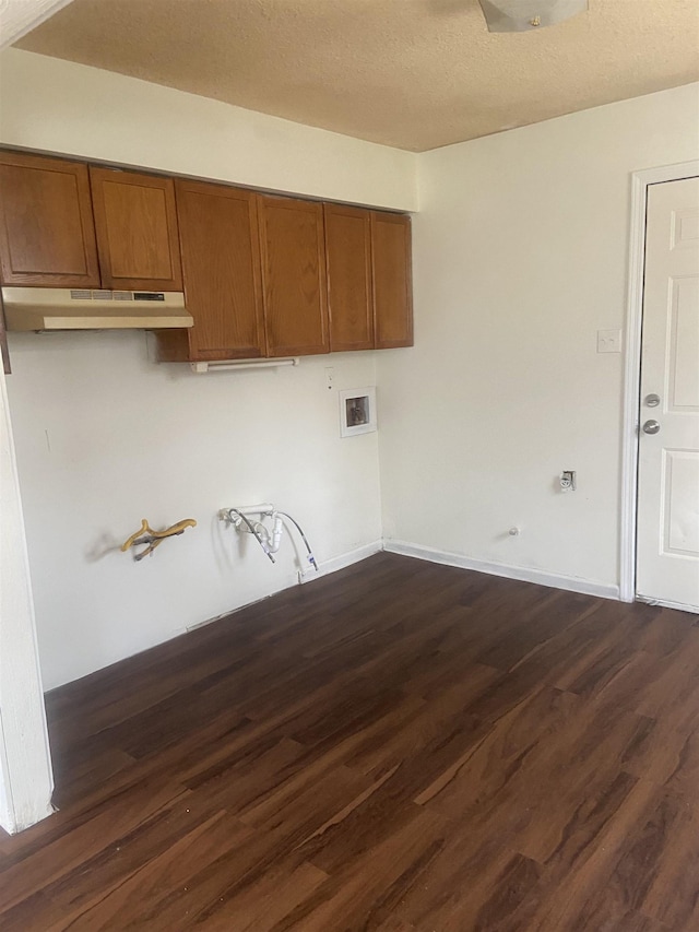 washroom with baseboards, cabinet space, a textured ceiling, and dark wood-style floors