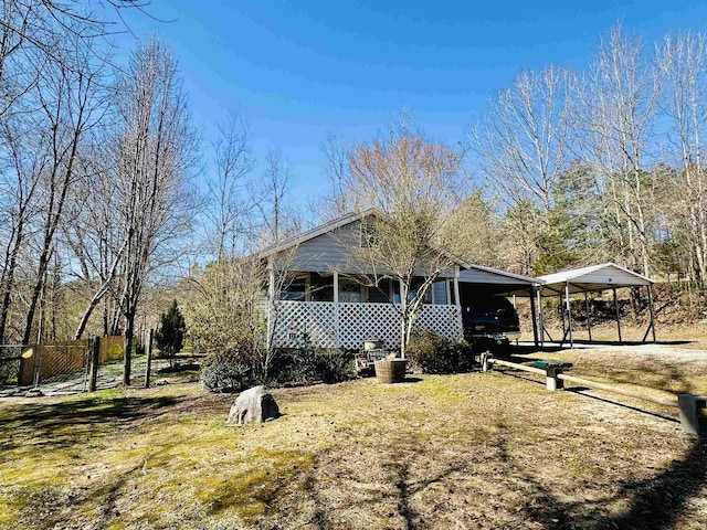 view of side of home with a detached carport and fence