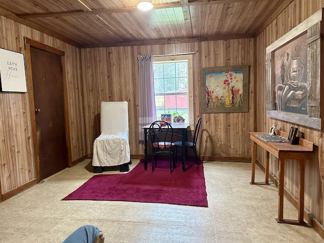 sitting room with tile patterned floors, wooden walls, and wood ceiling