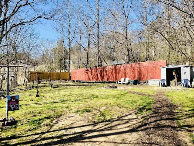 view of yard featuring a shed, an outdoor structure, and fence