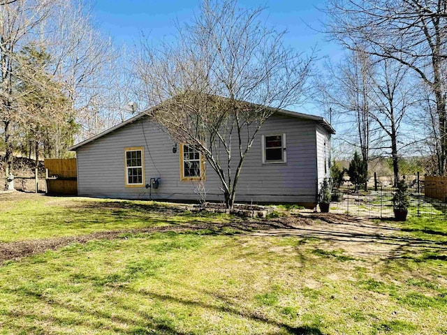 view of home's exterior featuring a lawn and fence