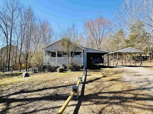 view of side of property with a carport, covered porch, and driveway