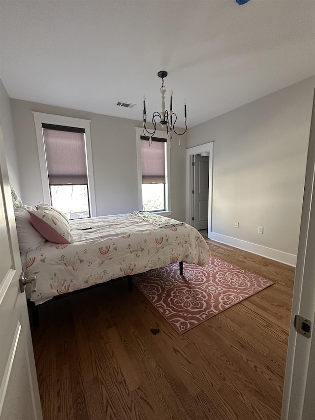 unfurnished bedroom with multiple windows, wood finished floors, and visible vents