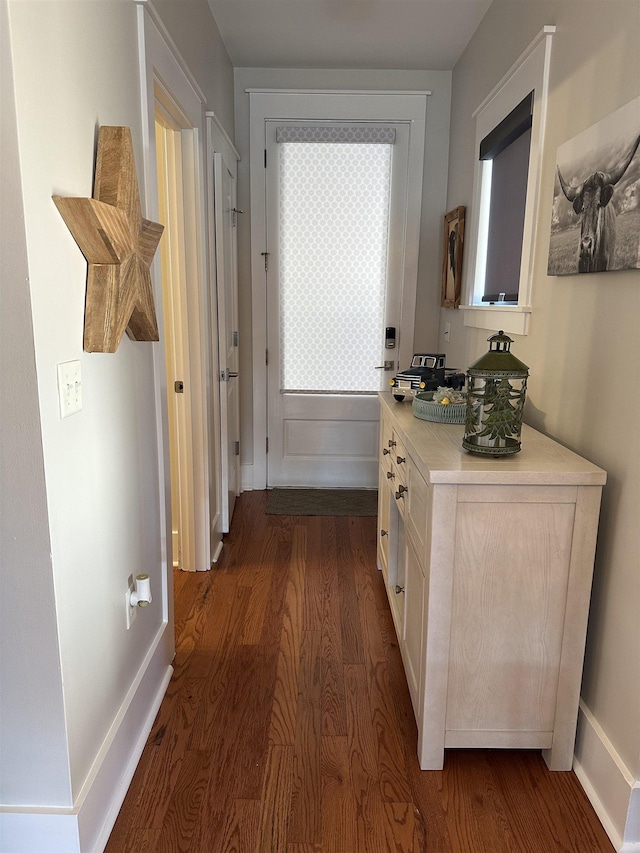 hall with baseboards and dark wood-style flooring