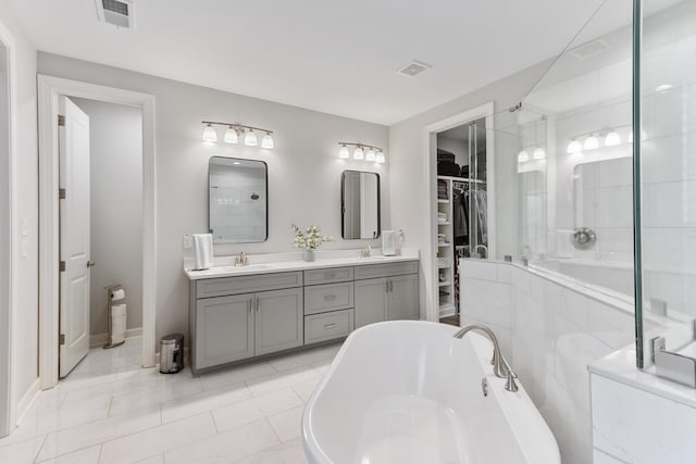 full bath with a soaking tub, visible vents, a tile shower, and a sink