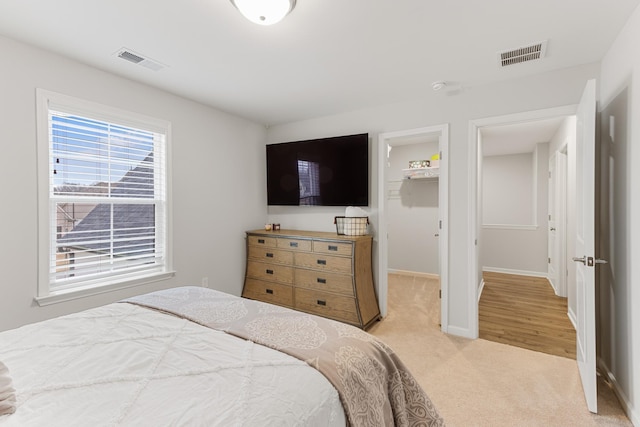 bedroom with visible vents, baseboards, and light colored carpet