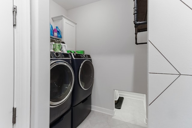 laundry room featuring washer and dryer, laundry area, light tile patterned floors, and baseboards