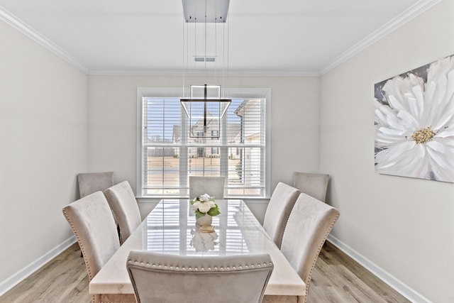 dining space featuring visible vents, light wood-style flooring, crown molding, and baseboards