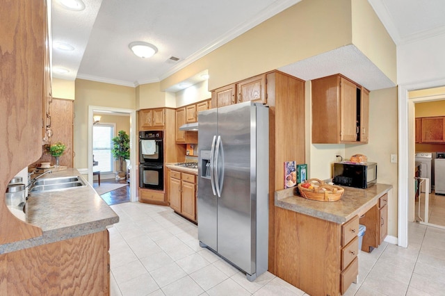 kitchen with visible vents, washing machine and dryer, ornamental molding, black appliances, and a sink