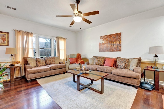 living room featuring dark wood-style floors, visible vents, crown molding, and ceiling fan