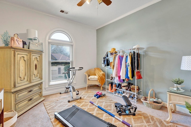 exercise area featuring visible vents, baseboards, ornamental molding, light carpet, and a ceiling fan