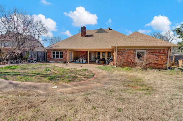 back of house with a patio, fence, brick siding, and a chimney