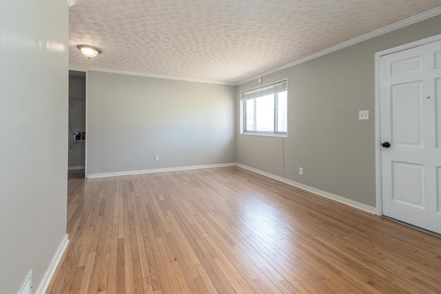 empty room with crown molding, baseboards, light wood finished floors, and a textured ceiling