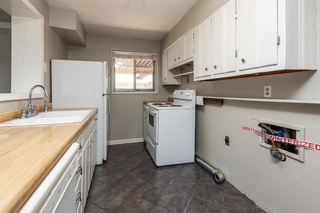 washroom featuring a sink, baseboards, and dark tile patterned flooring