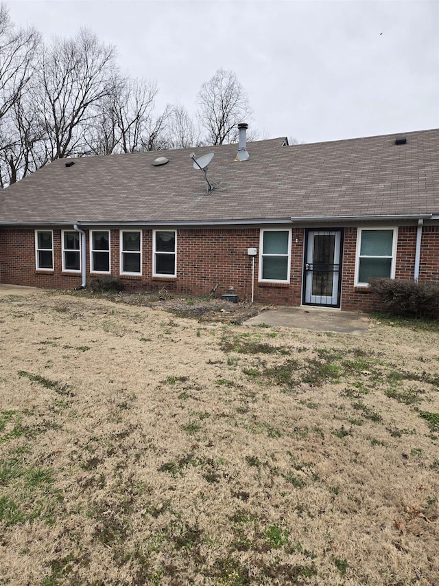 back of house with a patio, brick siding, and roof with shingles