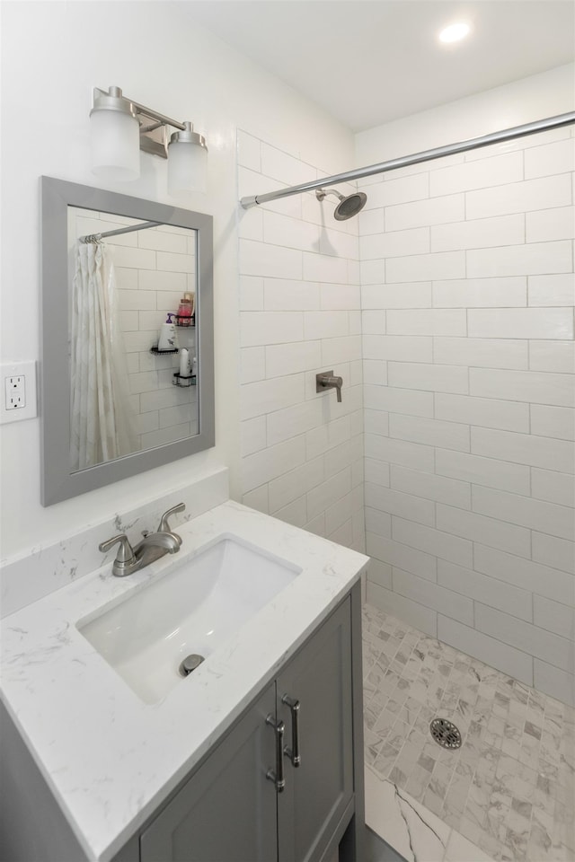 full bath featuring vanity and a tile shower