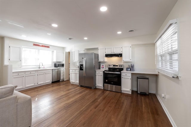 kitchen featuring visible vents, under cabinet range hood, a sink, white cabinetry, and appliances with stainless steel finishes