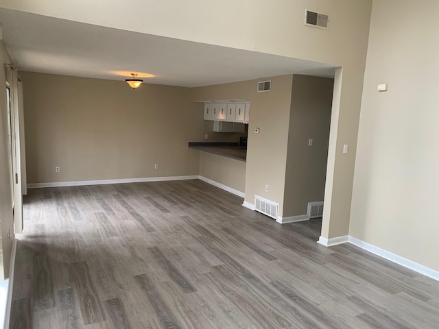 interior space featuring wood finished floors, visible vents, and baseboards