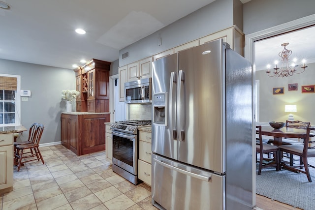 kitchen with light stone counters, decorative backsplash, recessed lighting, a notable chandelier, and stainless steel appliances