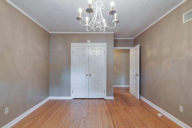 unfurnished bedroom with visible vents, baseboards, light wood-style floors, a closet, and crown molding