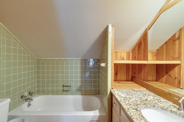 bathroom with vanity, vaulted ceiling, toilet, and a washtub