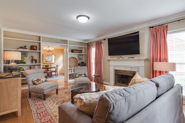 living area featuring a fireplace, crown molding, wood finished floors, and a healthy amount of sunlight