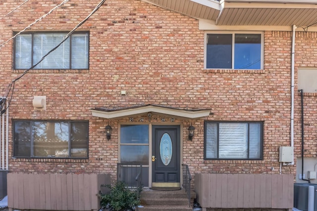 view of property featuring central air condition unit and brick siding