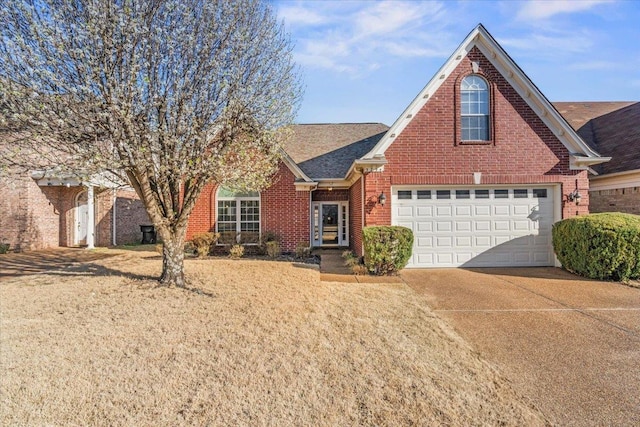 traditional-style house with brick siding, concrete driveway, and a shingled roof