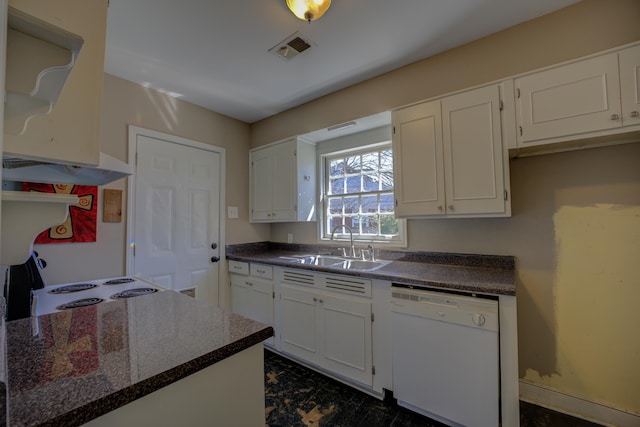 kitchen with dark countertops, visible vents, white dishwasher, white cabinetry, and a sink