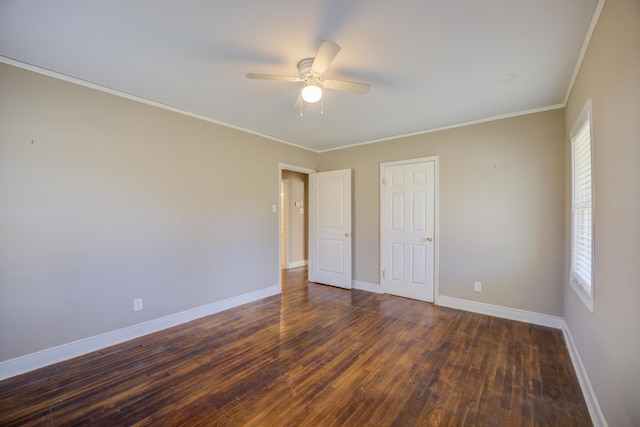 unfurnished bedroom with multiple windows, crown molding, baseboards, and wood finished floors