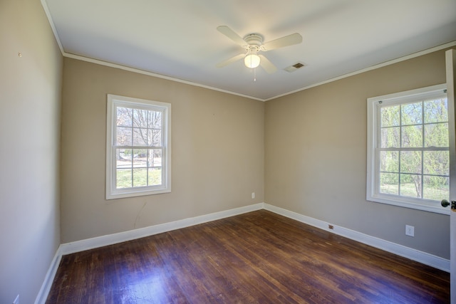 spare room featuring visible vents, baseboards, ornamental molding, and dark wood-style flooring