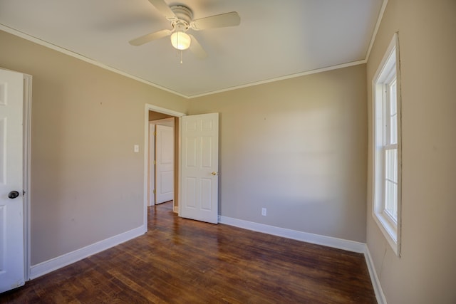 empty room featuring baseboards, a ceiling fan, dark wood finished floors, and crown molding