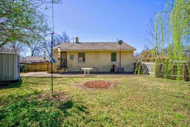 rear view of property featuring a patio, a yard, fence, and brick siding