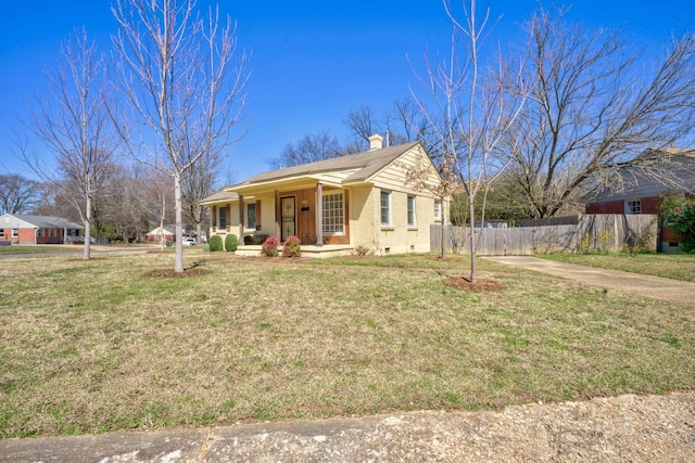 view of front of property with brick siding, a chimney, a front lawn, and fence