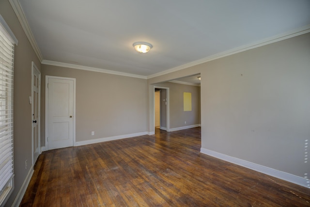 spare room with crown molding, baseboards, and dark wood-style flooring