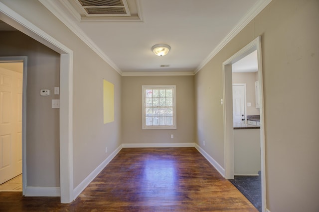 unfurnished room with baseboards, wood finished floors, visible vents, and ornamental molding