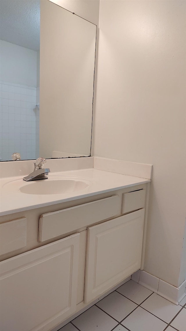 bathroom with baseboards, vanity, and tile patterned flooring