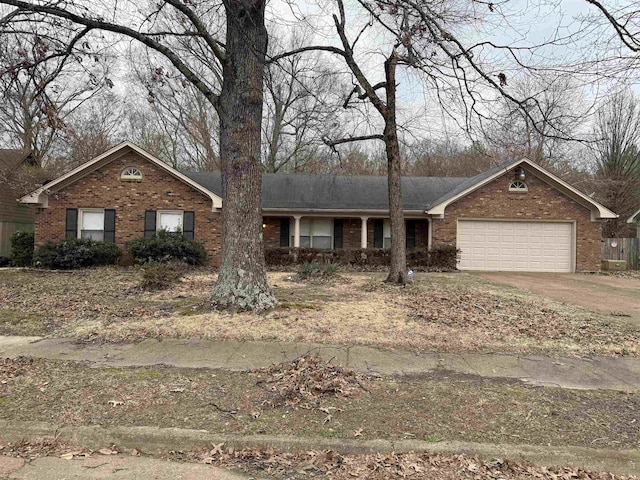 ranch-style house featuring brick siding, driveway, and an attached garage