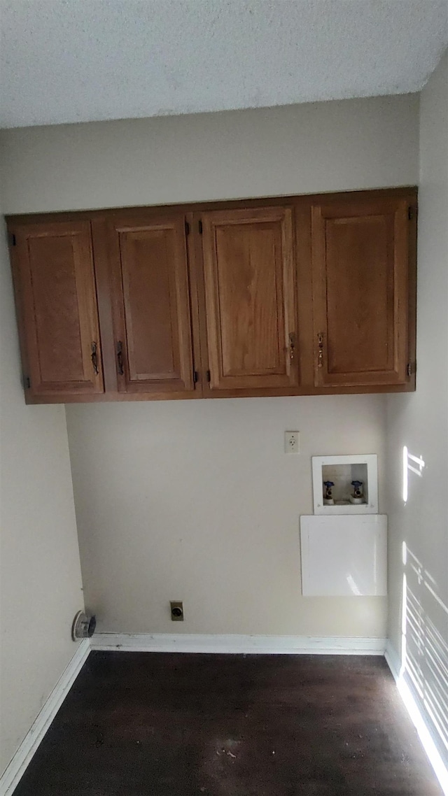 washroom with baseboards, hookup for a washing machine, wood finished floors, cabinet space, and a textured ceiling