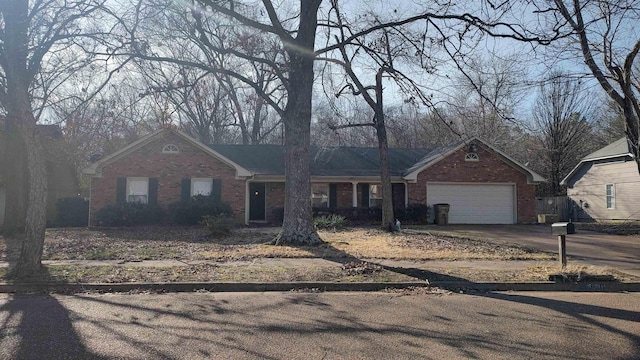 single story home with brick siding, an attached garage, and concrete driveway