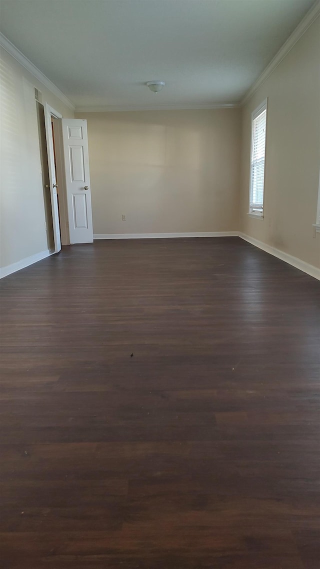 unfurnished room featuring dark wood-style floors, crown molding, and baseboards