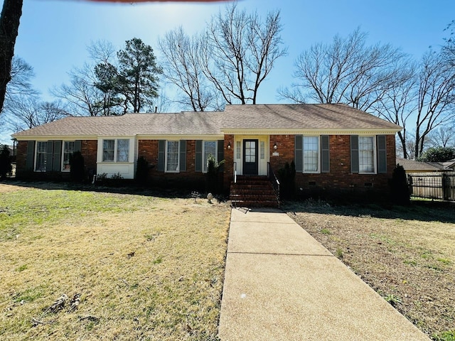 ranch-style house featuring brick siding, crawl space, and a front lawn