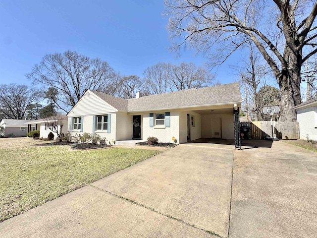 ranch-style house with brick siding, a front lawn, fence, a chimney, and driveway