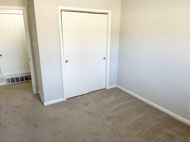 unfurnished bedroom with a closet, baseboards, visible vents, and carpet floors